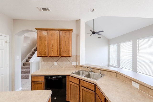 kitchen featuring tasteful backsplash, ceiling fan, sink, light tile patterned floors, and black dishwasher