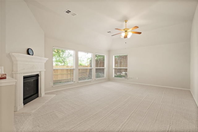 unfurnished living room with a tile fireplace, ceiling fan, light colored carpet, and vaulted ceiling