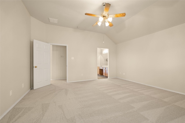 unfurnished bedroom with ceiling fan, light carpet, connected bathroom, and vaulted ceiling