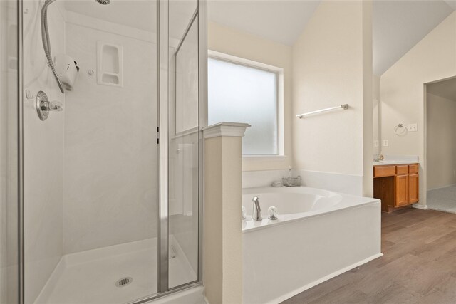 bathroom featuring vanity, plus walk in shower, lofted ceiling, and hardwood / wood-style flooring