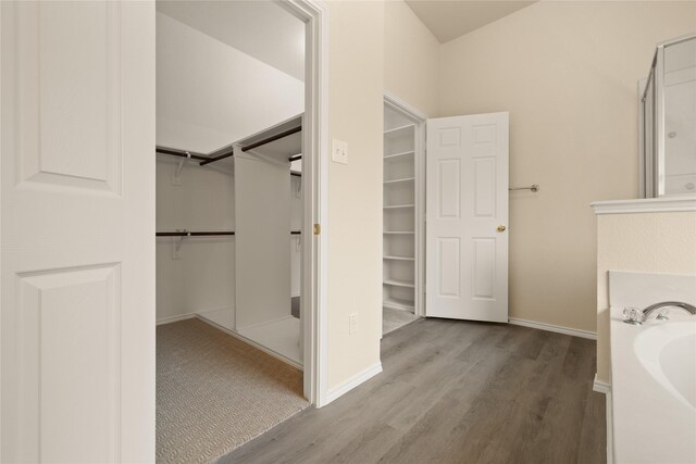 bathroom with a bath and wood-type flooring