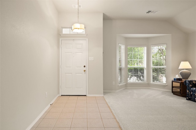 carpeted entrance foyer with vaulted ceiling