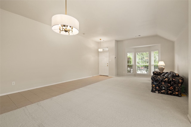 living room featuring lofted ceiling, carpet floors, and an inviting chandelier