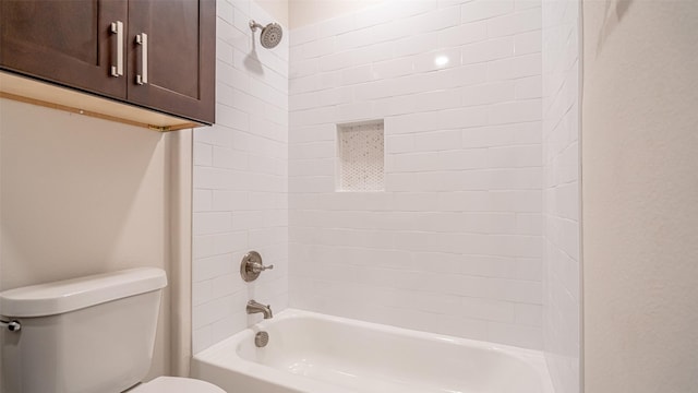 bathroom featuring tiled shower / bath combo and toilet