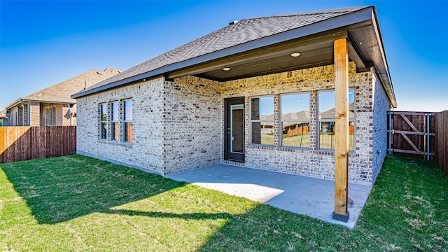 back of house with a patio and a yard