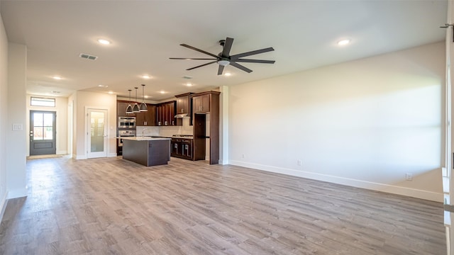 kitchen featuring pendant lighting, sink, ceiling fan, a center island, and light hardwood / wood-style floors