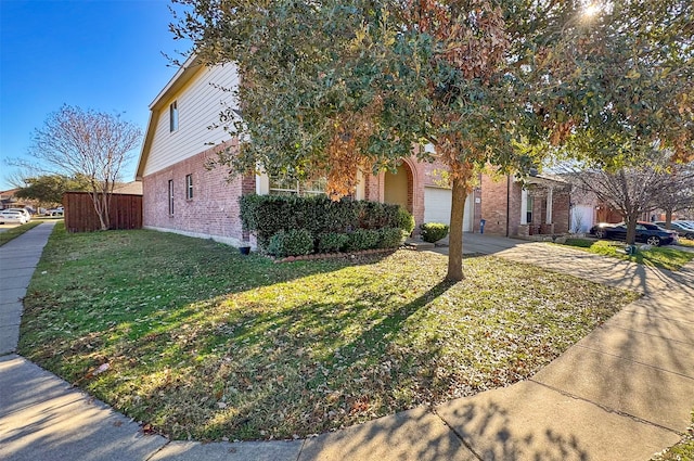 view of property hidden behind natural elements featuring a garage and a front lawn