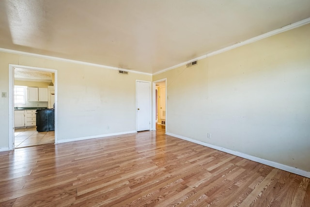 empty room with light wood-type flooring and ornamental molding