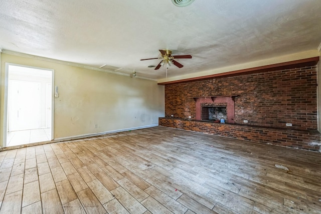 unfurnished living room with a fireplace, a textured ceiling, hardwood / wood-style flooring, and ceiling fan