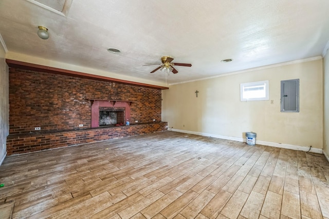 unfurnished living room featuring electric panel, ceiling fan, wood-type flooring, and a brick fireplace