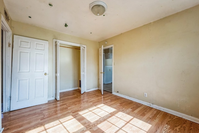 unfurnished bedroom with a closet and light hardwood / wood-style flooring