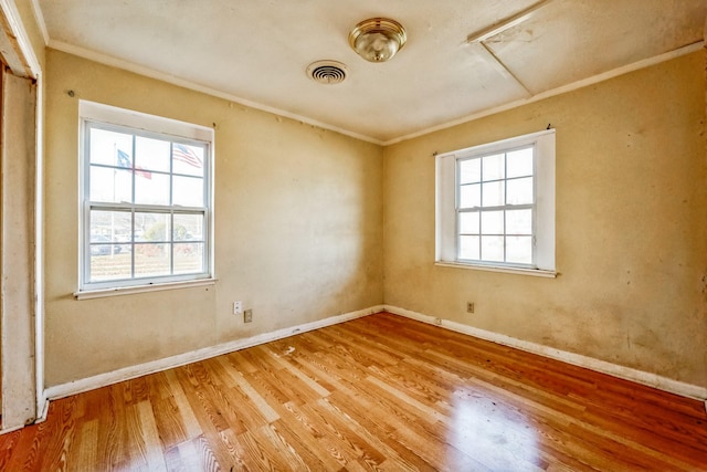 spare room with crown molding and light hardwood / wood-style flooring