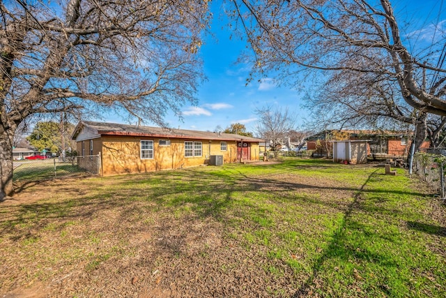 view of yard featuring a shed and central AC