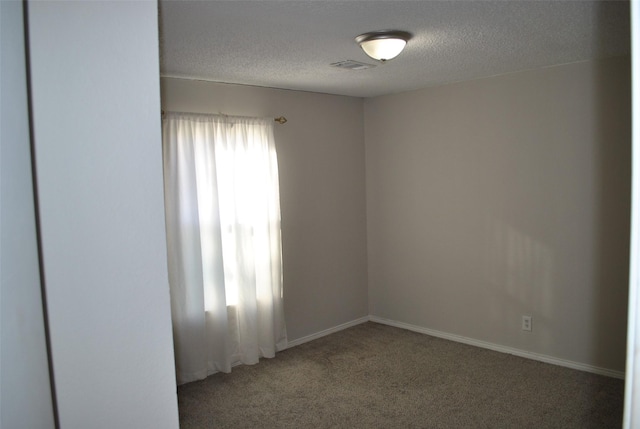 unfurnished room featuring carpet and a textured ceiling