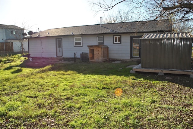 rear view of property with a lawn and central AC