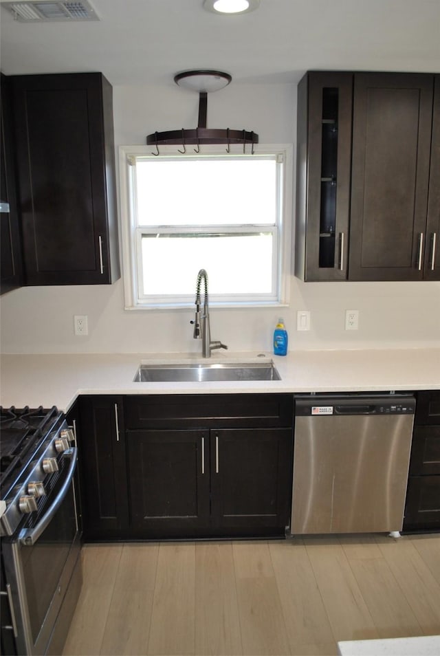 kitchen featuring light hardwood / wood-style floors, sink, dark brown cabinetry, and stainless steel appliances