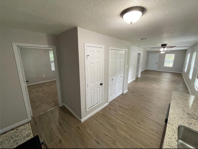 corridor featuring dark wood-type flooring and a textured ceiling