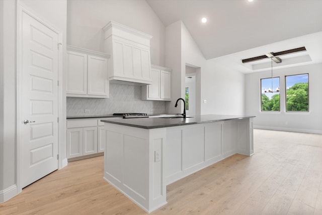 kitchen featuring white cabinetry, light hardwood / wood-style floors, a kitchen island with sink, and sink