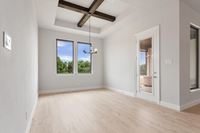 unfurnished room with coffered ceiling, a notable chandelier, beam ceiling, and light hardwood / wood-style flooring