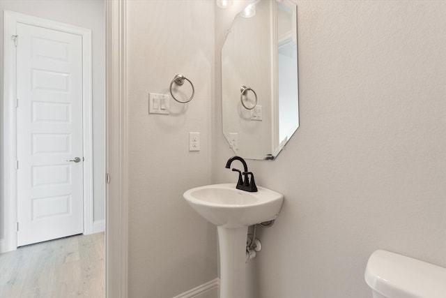 bathroom featuring hardwood / wood-style flooring and toilet