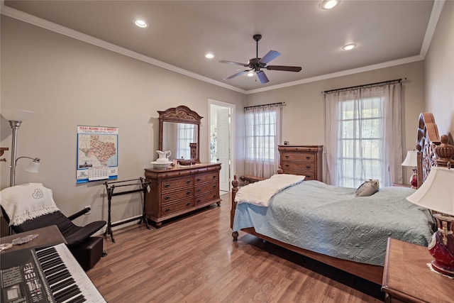 bedroom with hardwood / wood-style flooring, ceiling fan, and ornamental molding