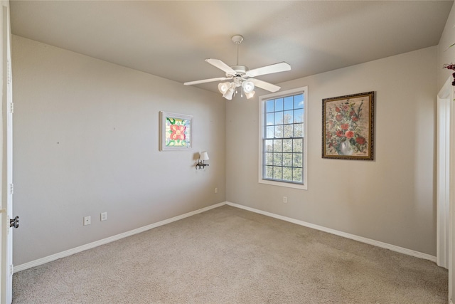 carpeted spare room featuring ceiling fan