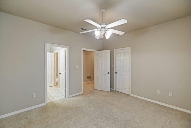 unfurnished bedroom with light colored carpet and ceiling fan