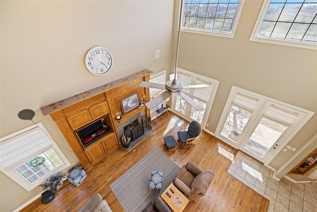 living room with ceiling fan and a towering ceiling