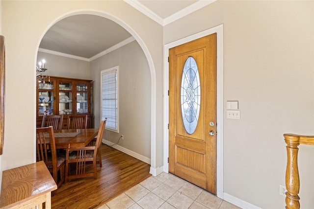 entryway with a healthy amount of sunlight, light tile patterned floors, and ornamental molding