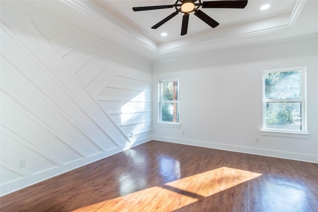 unfurnished room featuring a raised ceiling, ornamental molding, and dark hardwood / wood-style floors