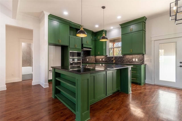 kitchen featuring dark stone countertops, hanging light fixtures, green cabinetry, a kitchen island, and decorative backsplash