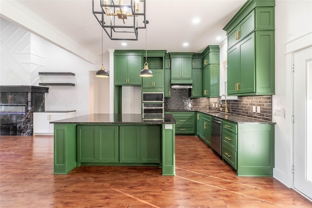 kitchen with pendant lighting, appliances with stainless steel finishes, green cabinets, and a kitchen island