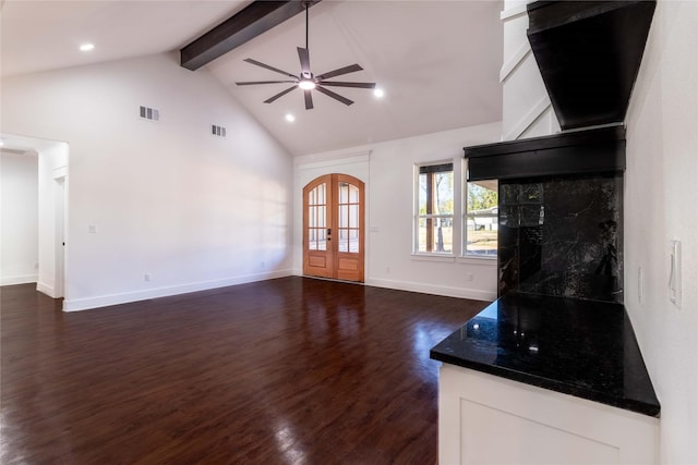 unfurnished living room with dark wood-type flooring, ceiling fan, beam ceiling, high vaulted ceiling, and french doors