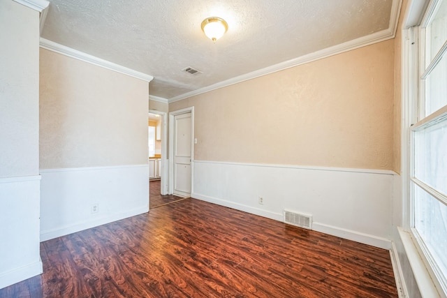 spare room with crown molding, dark hardwood / wood-style floors, and a textured ceiling