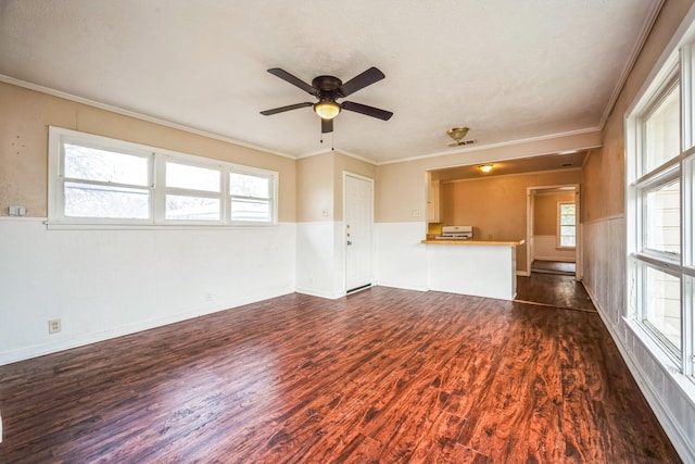 unfurnished living room featuring crown molding, ceiling fan, and dark hardwood / wood-style floors