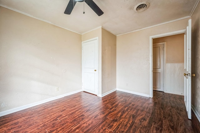 spare room featuring crown molding, dark wood-type flooring, and ceiling fan