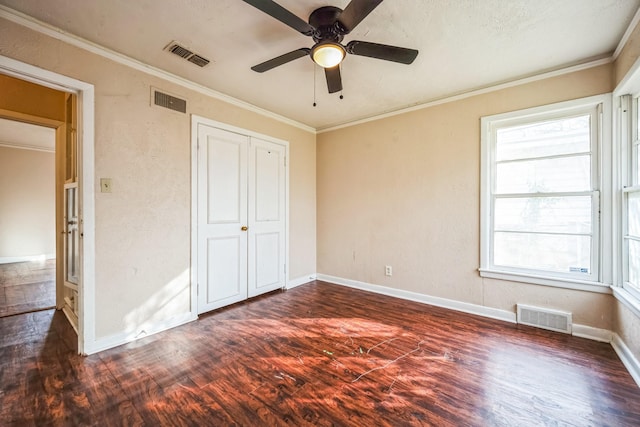 unfurnished bedroom with ceiling fan, dark hardwood / wood-style flooring, crown molding, and multiple windows