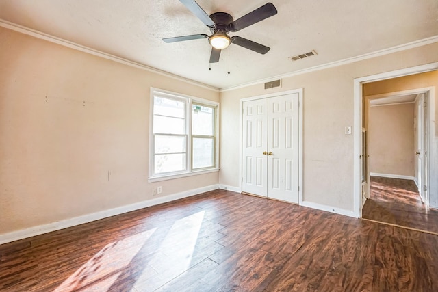 unfurnished bedroom featuring ornamental molding, dark hardwood / wood-style floors, ceiling fan, and a closet