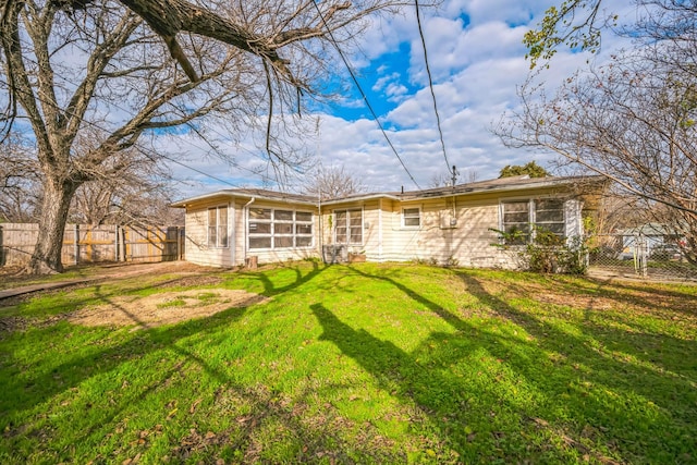 back of property with a yard and a sunroom