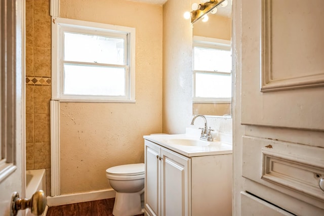 full bathroom with vanity, tiled shower / bath combo, wood-type flooring, and toilet