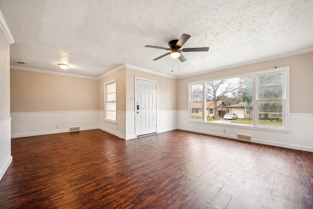 spare room featuring a textured ceiling, ceiling fan, dark hardwood / wood-style floors, and ornamental molding