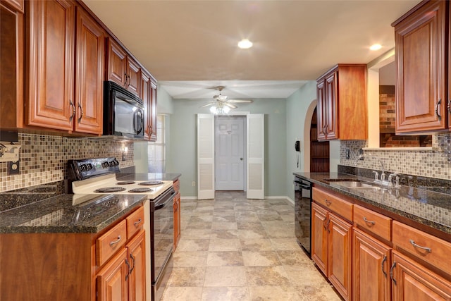 kitchen with black appliances, sink, ceiling fan, decorative backsplash, and dark stone countertops