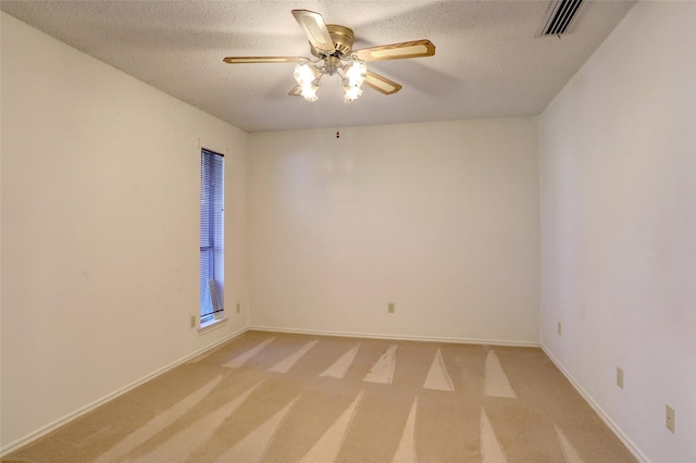 empty room featuring a textured ceiling, light colored carpet, and ceiling fan