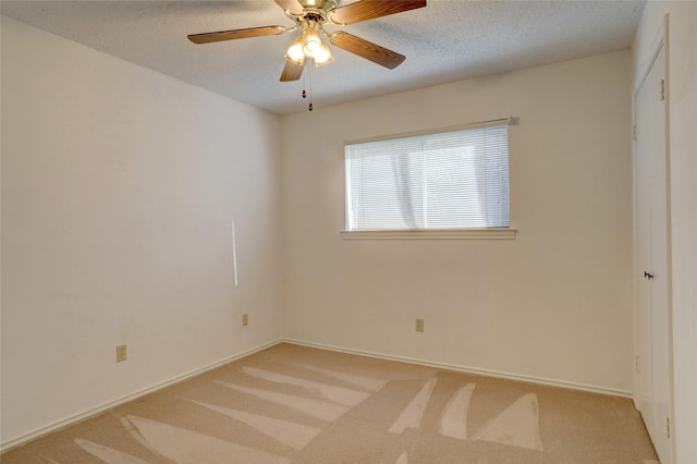 carpeted spare room with ceiling fan and a textured ceiling