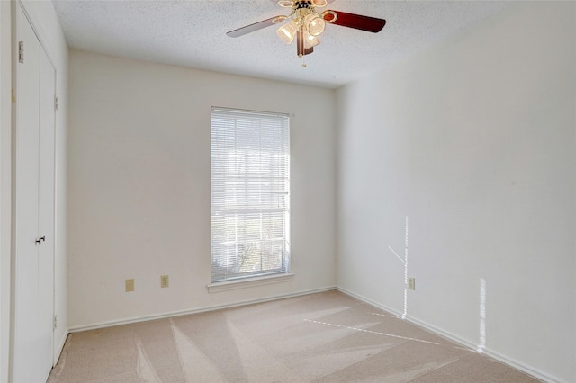 unfurnished room with light carpet, a textured ceiling, and ceiling fan