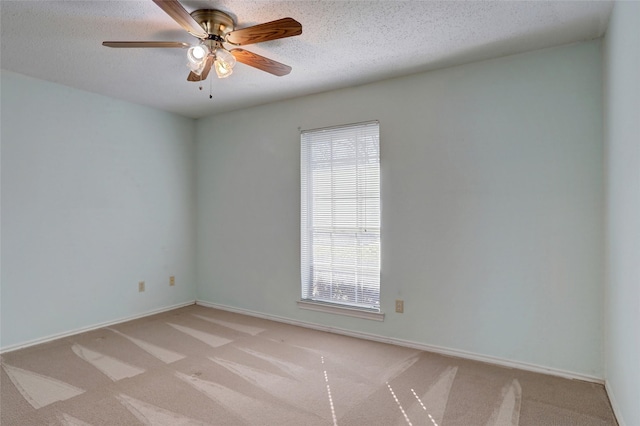 carpeted spare room featuring ceiling fan and a textured ceiling