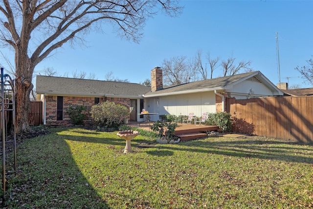 back of property featuring a lawn and a wooden deck