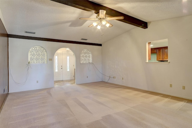 spare room with light carpet, a textured ceiling, lofted ceiling with beams, and ceiling fan