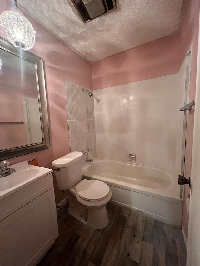 full bathroom featuring hardwood / wood-style floors, vanity, shower / bathing tub combination, toilet, and a textured ceiling