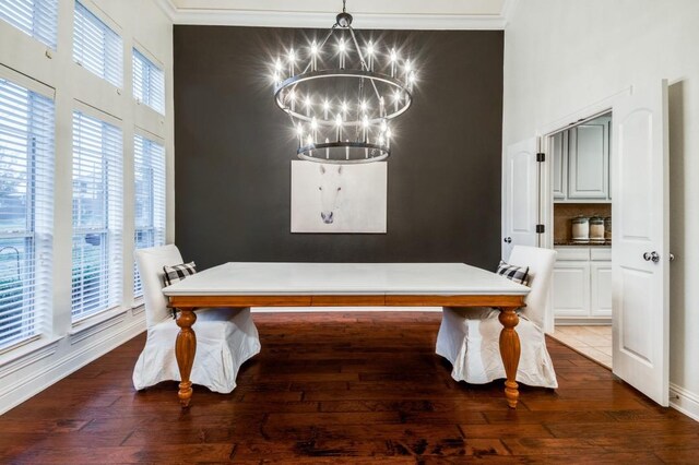 dining space with dark wood-type flooring, a wealth of natural light, and a chandelier